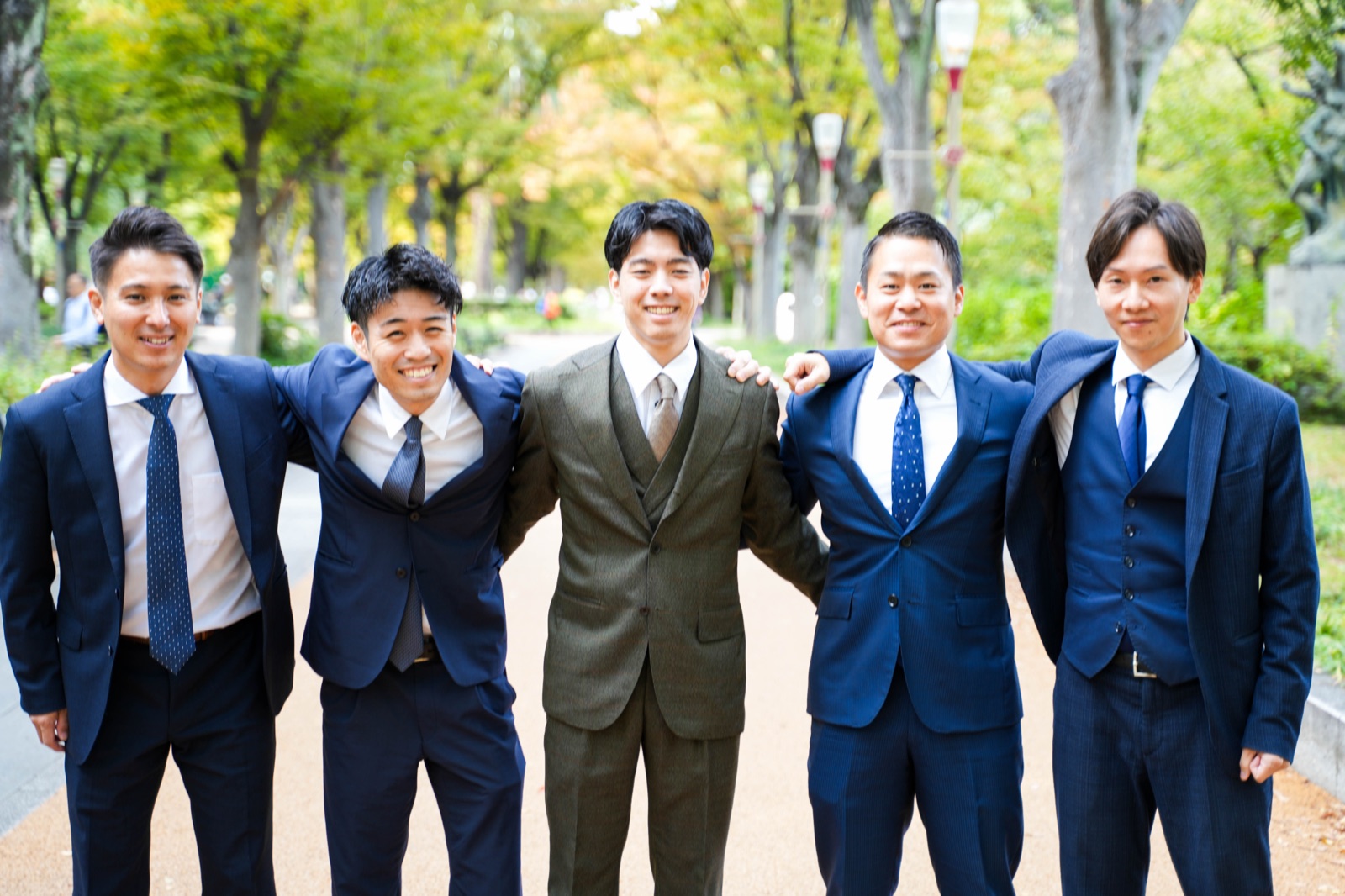 並木道で肩を組んで並ぶXtoXのメンバー5人