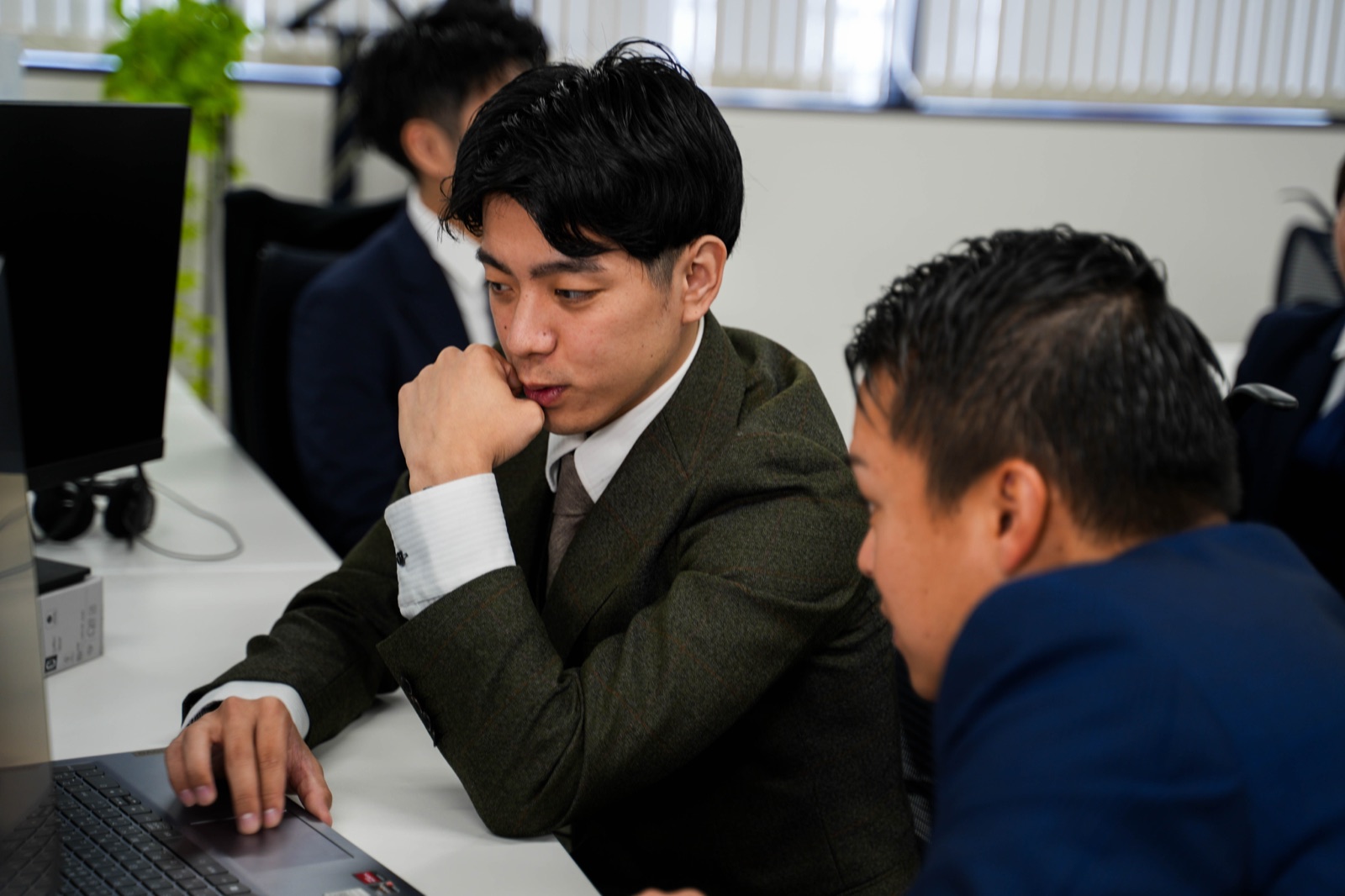 オフィスでPCを囲んで議論するXtoXのメンバー